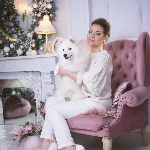 A serene woman with closed eyes, meditating in a calm environment with warm ambient light.